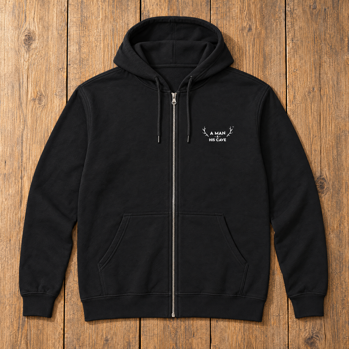 Black AMAHC embroidered zip hoodie laid flat on timber
