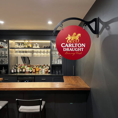 Carlton Draught round metal sign displayed in an indoor home bar