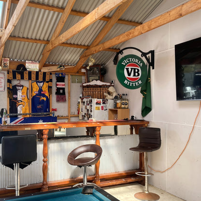 Victoria Bitter round metal sign displayed in a man cave bar