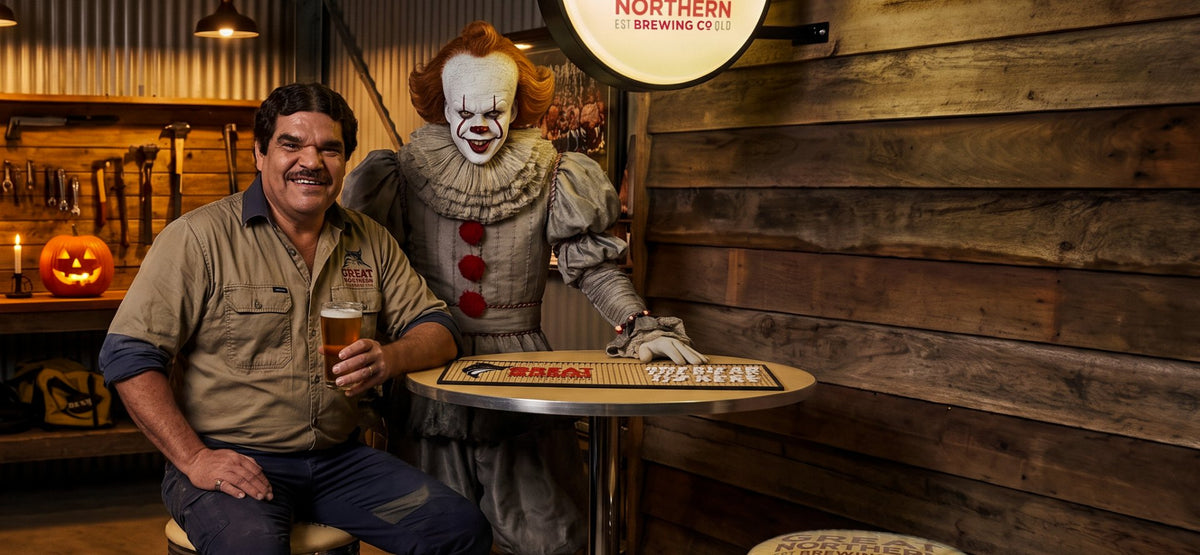 A tradie with a beer and a horror clown at a Great Northern bar table in a shed