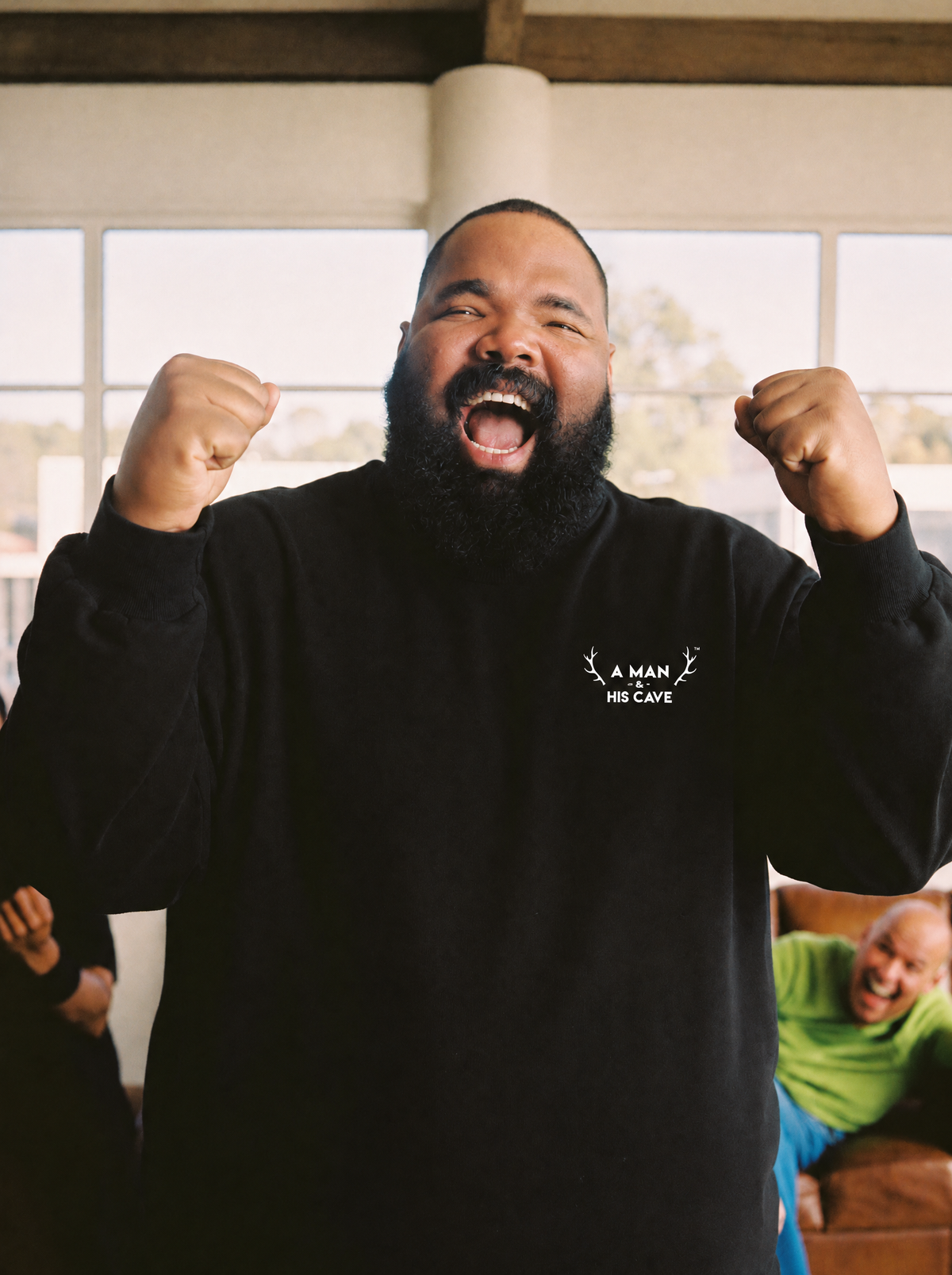 Big bloke cheering in the black AMAHC logo crew sweatshirt