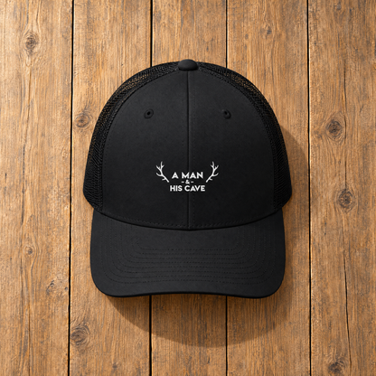 Black AMAHC logo trucker cap on timber