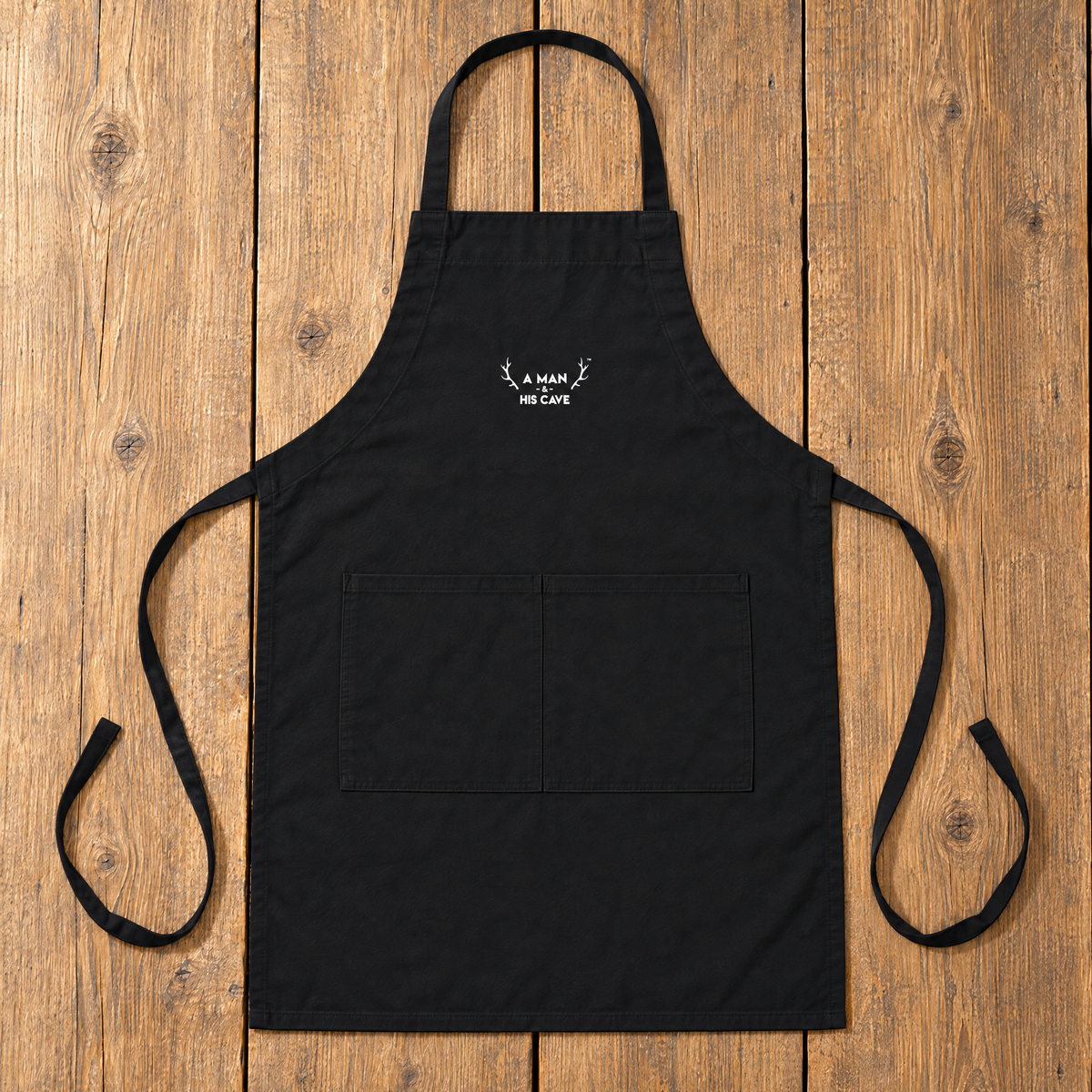 Black AMAHC logo BBQ apron laid flat on timber