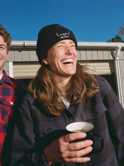Woman laughing outside the shed in the black AMAHC logo beanie