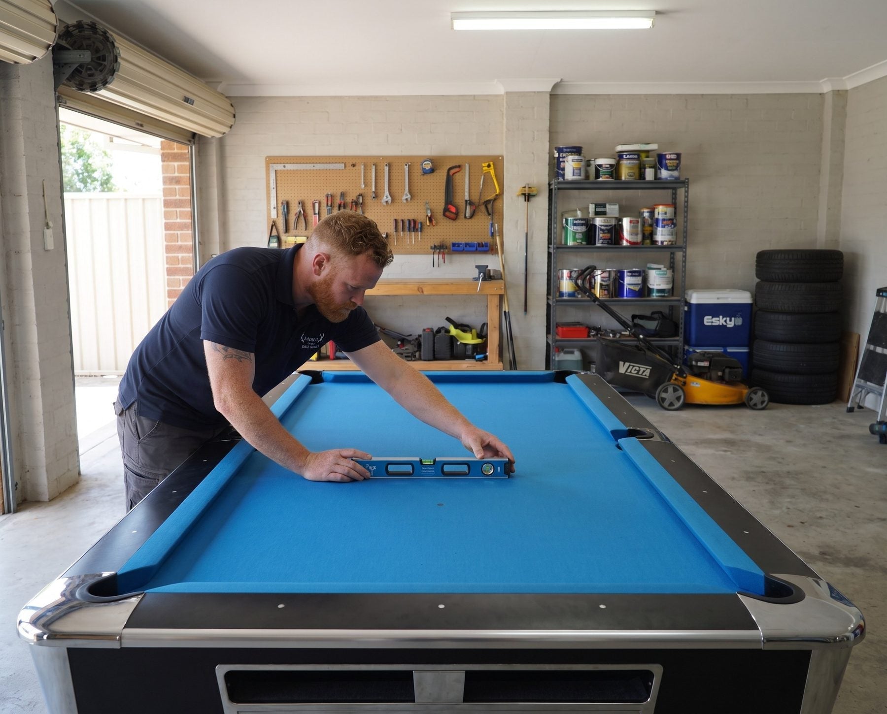 An installer levelling a pool table in a garage